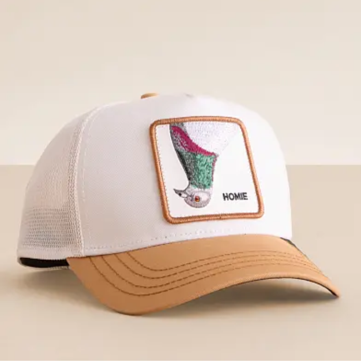 White cap with brown bill featuring a duck design on a beige background