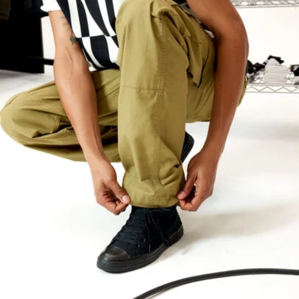 Black high-top sneakers on a white background with Converse branding.