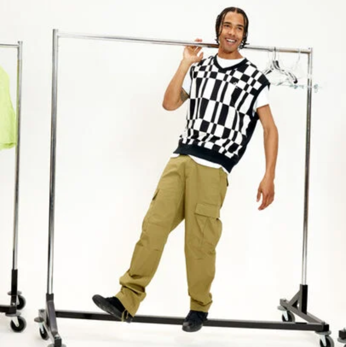 Person wearing a checkered shirt and beige pants on a Converse website page.