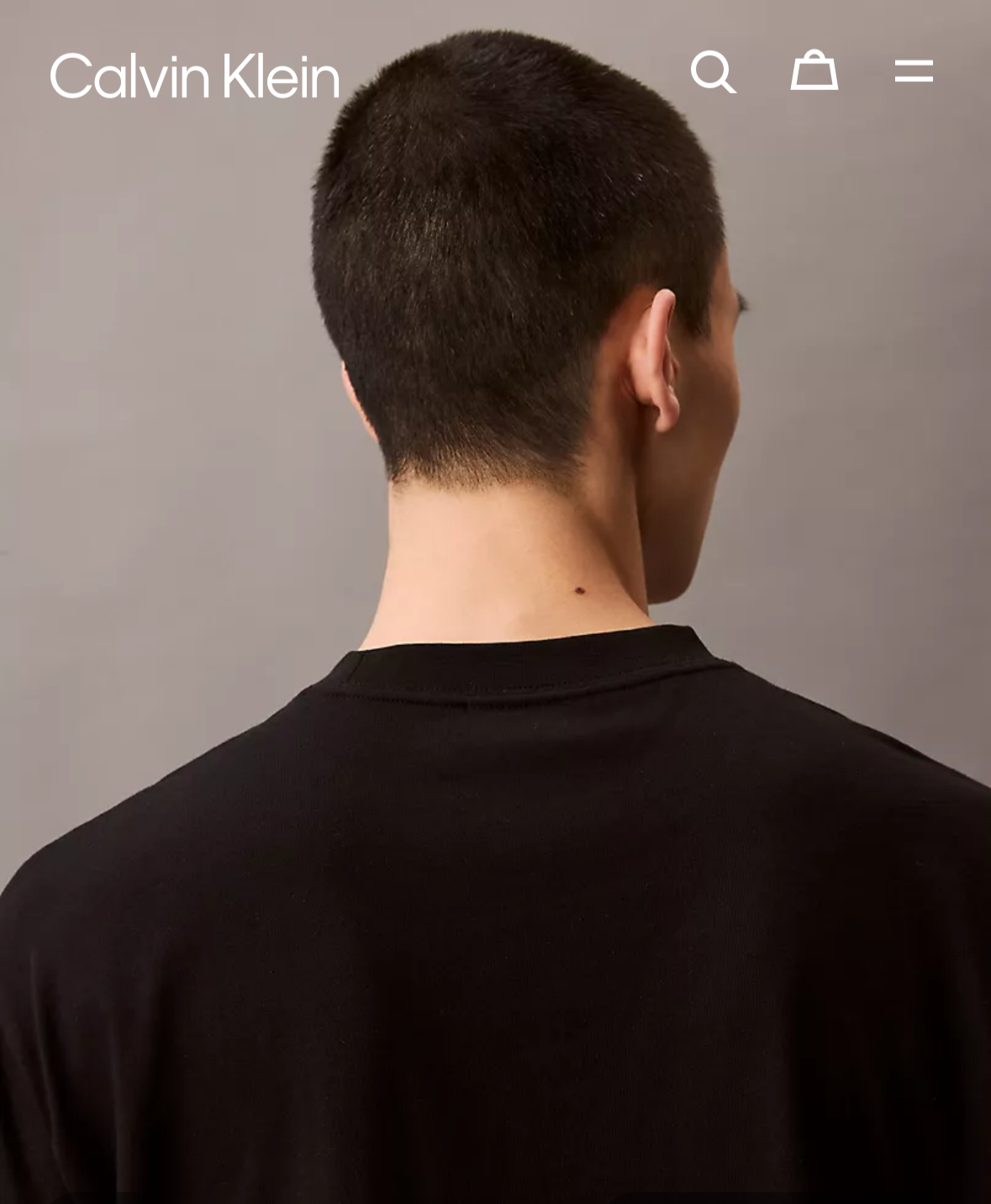 Person wearing a black Calvin Klein shirt on a website homepage